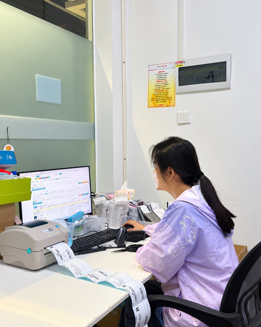 A Bitus staff member printing shipping labels at the packing station